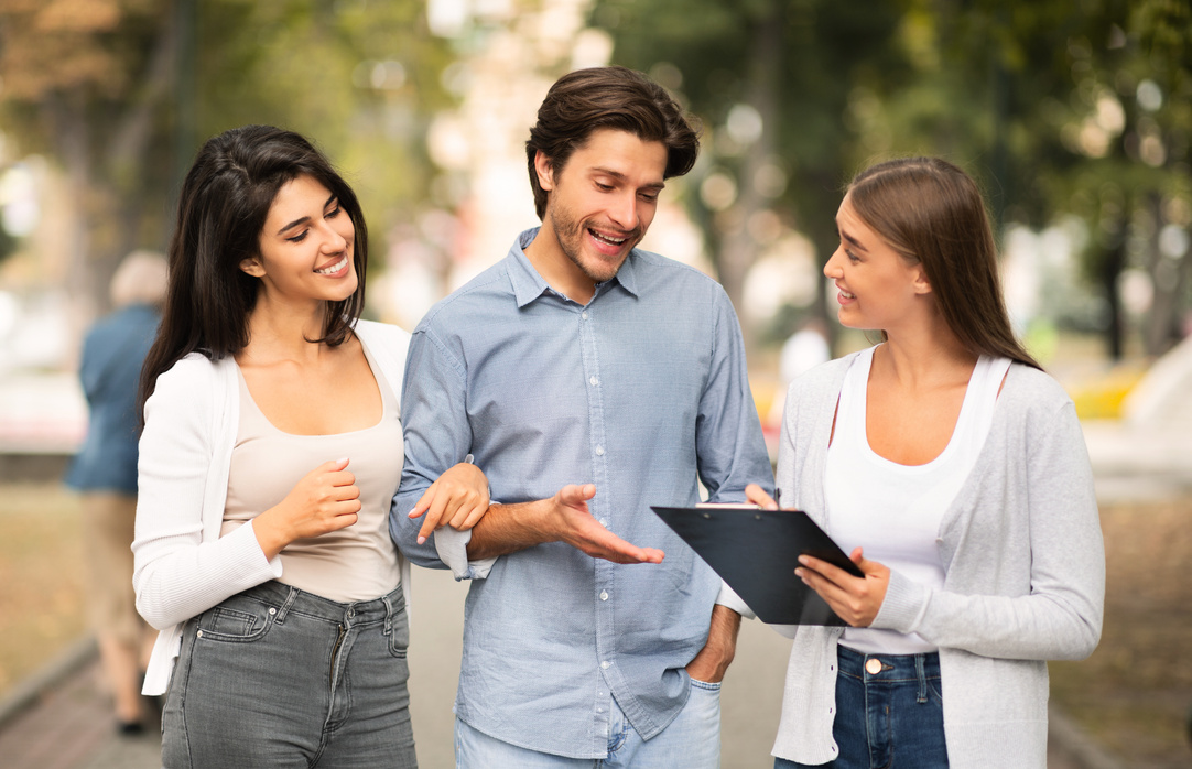 Girl Interviewing Young Couple Conducting Sociological Survey Standing Outdoor